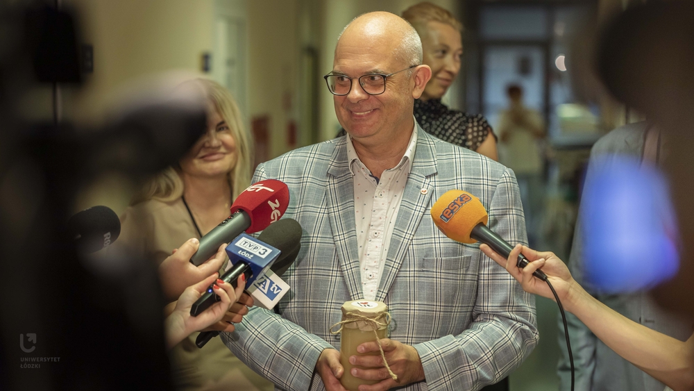 Prof. Robert Zakrzewski during a media briefing with a jar of honey in his hands