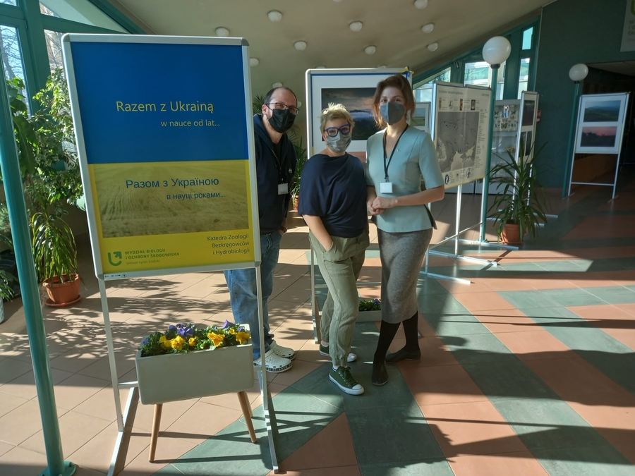 two women and a man wearing protective face masks at a photo exhibition
