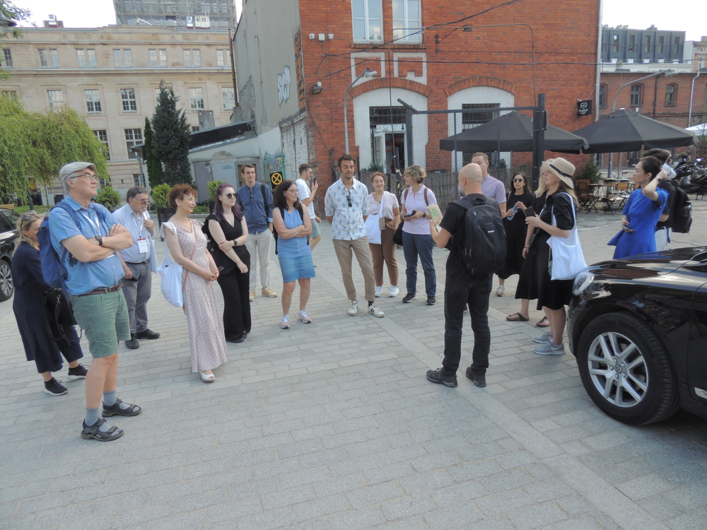 A group of people standing and listening to a city guide