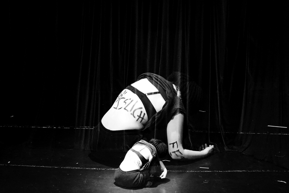 A still from a theatrical play, a black and white high-contrast photograph showing a fragment of a woman's body in underwear