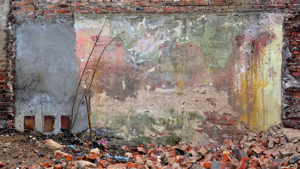 a photo of a multi-coloured wall with bricks lying in front of it