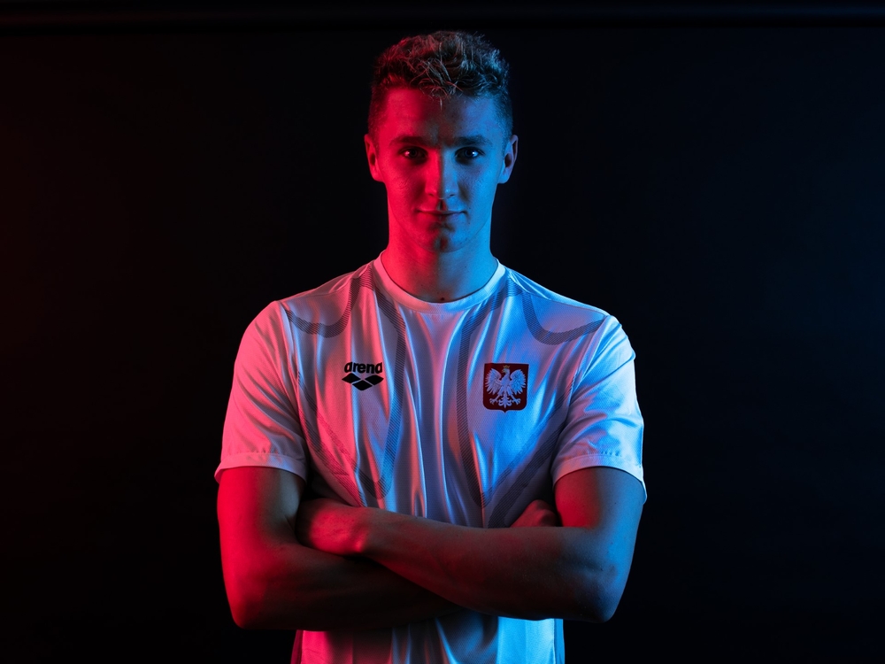a portrait photo of Jakub Kraska against a dark background with a red glow