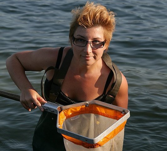 A woman with a fishing net in the water